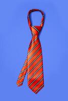 rood Mannen gestreept stropdas genomen uit voor vrije tijd tijd, geïsoleerd Aan blauw achtergrond. foto