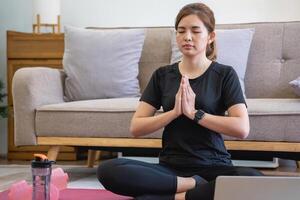 gezond jong vrouw aan het doen ademen opdrachten Bij huis, mooi vrouw mediteren Bij huis met ogen gesloten, beoefenen yoga, aan het doen pranayama technieken opmerkzaamheid meditatie concept foto