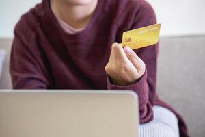 mooi Aziatisch Dames gebruik makend van credit kaarten voor boodschappen doen online met laptops en smartphones, online boodschappen doen portret concept. foto