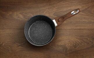 frituren pan met niet-klevend graniet coating geïsoleerd Aan een houten foto