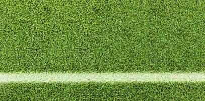 groen gras structuur achtergrond. kunstmatig groen gras. wit lijn Aan de voetbal veld. foto