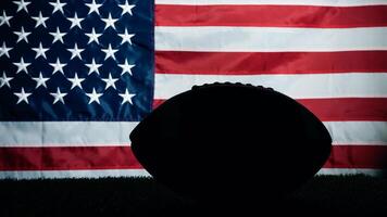 silhouet van Amerikaans Amerikaans voetbal bal tegen Verenigde Staten van Amerika vlag foto
