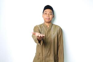 verheugd Aziatisch moslim Mens vervelend koko kleren presenteren Bij camera met Open palm geïsoleerd Aan wit achtergrond foto