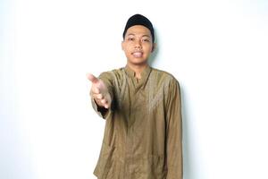 gelukkig Aziatisch moslim Mens vervelend koko kleren aanbieden vriendelijk handdruk Bij camera geïsoleerd Aan wit achtergrond foto