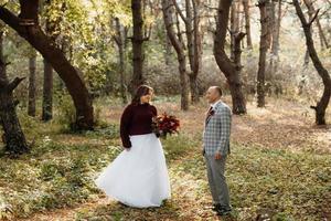 wandeling van de bruid en bruidegom door het herfstbos foto