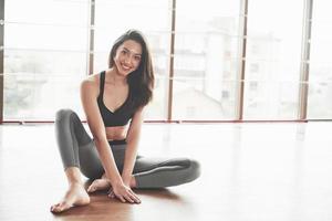 een gymnaste vrouw uitrekken maakt een splitsing, een touw in een sportschool. foto