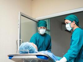 ziekenhuis kliniek operatie kamer binnen- dokter verpleegster personeel bijstand persoon mensen menselijk wandelen een patiënten bed dokter verpleegster personeel bijstand slijtage uniform masker bed Gezondheid gang noodgeval ondersteuning foto