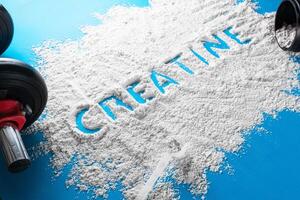 de woord creatine geschreven Aan een wit poeder. welzijn concept. foto