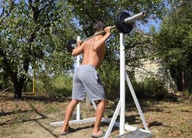 Mens duurt een bar naar uitvoeren hurken. opdrachten in bodybuilding. sp foto