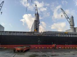 kraan Aan een lading schip in de haven. foto