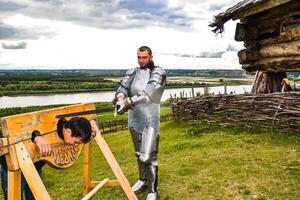 dramatisering straf in de midden- leeftijden. ridder zwaaide zijn zwaard Bij de gevangene. foto