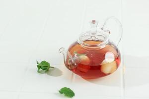 transparant theepot met lychee thee en munt blad foto