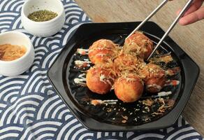 nemen eigengemaakt takoyaki gebruik makend van roestvrij eetstokje foto