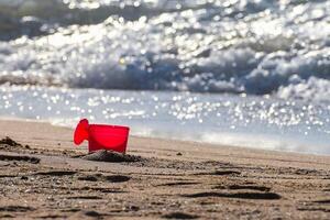 plastic kan scheppen omhoog roze zand Bij pattaya strand. foto