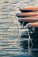 zon schittering Aan glanzend bord boten, azuur water, kalmte in haven Hercules, bogen van afgemeerd boten Bij zonnig dag, megajachten, Monaco, monte-carlo foto