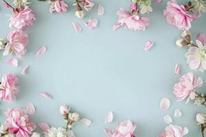 ai gegenereerd een karton kader van roze bloemen Aan een licht blauw achtergrond foto