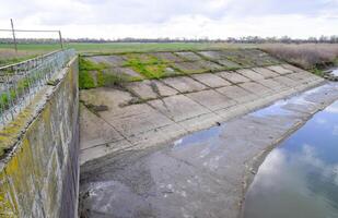 geplaveid beton banken van de irrigatie kanaal Bij de stopcontact van th foto