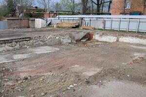 geruïneerd fundament van een oud gebouw, de muren van de kelder van een afgebroken gebouw en brokstukken. foto