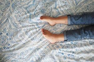 kaal voeten van een kind Aan wit bed foto