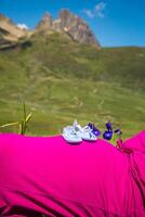 zwanger vrouw aan het liegen Aan een gras met baby schoenen Aan haar buik foto