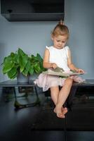 aanbiddelijk kleuter weinig meisje lezing boek Bij huis. geluk kind lezing boek voor peuter- genieten met aan het leren onderwijs door jezelf. onderwijs concept foto