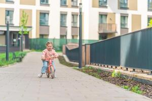 weinig meisje rijden balans fiets in de binnenplaats van de residentie in Praag, Europa foto