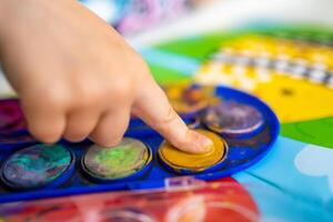 de kind vult in de leeg ruimtes. ideeën voor vinger schilderen. vinger schilderij taak voor kinderen. weinig meisje trekt met verven. kinderen ontwikkeling concept. foto