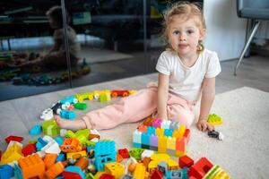 weinig meisje Speel met bouwer speelgoed- Aan verdieping in huis, leerzaam spel, uitgeven vrije tijd activiteiten tijd concept foto