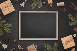 schoolbordmodel omringd door kerstversieringen. leeg bord voor begroetingstekst foto