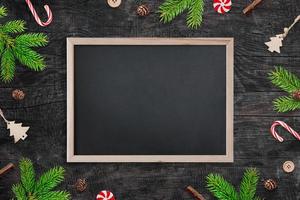 schoolbordmodel omringd door kerstversieringen. leeg bord voor begroetingstekst foto