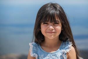 portret van een weinig spaans meisje Aan een mooi blauw lucht achtergrond. foto