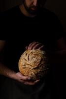 aantrekkelijk jong Kaukasisch chef poseren met wit zuurdesem brood. foto