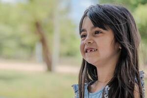 portret van een meisje pratend dat ze is missend een van haar voorkant tanden. foto