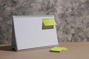 leeg kalender tafel en blanco groen Notitie papier gehecht, geschikt voor toekomst gebruik in uw bedrijf model, abstract grijs achtergrond foto