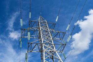 ondersteunt hoog voltage macht lijnen tegen de blauw lucht met wolken. elektrisch industrie foto