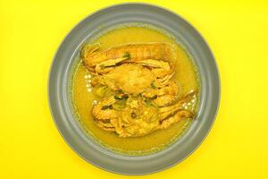 pittig krab in kerrie saus Aan geel achtergrond, Thais voedsel. foto