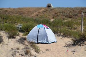 toerist tent Aan de zand. parkeren van toeristen Aan de zanderig strand foto