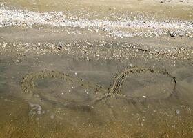 de teken van oneindigheid Aan de zee. kust- zand Aan de strand. de symbool van oneindigheid foto