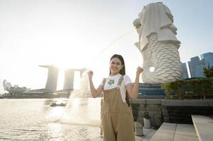 een vrouw in merlion fontein in voorkant van de jachthaven baai foto