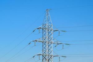 ondersteunt hoog voltage macht lijnen tegen de blauw lucht foto