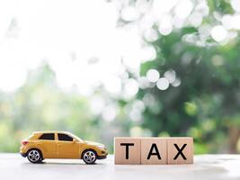 speelgoed- auto en houten blokken met de woord belasting . de concept voor betalen belasting voor auto in toekomst foto