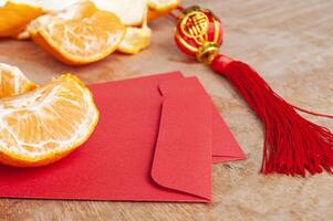 peal mandarijn- sinaasappels en Chinese nieuw jaar rood envelop. Chinese nieuw jaar viering concept foto