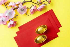 top visie van Chinese nieuw jaar rood pakketten en gouden ingots. Chinese nieuw jaar viering concept foto