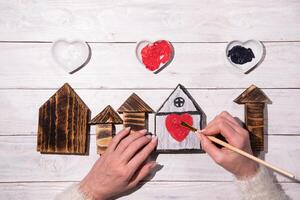 vrouw handen trek een hart Aan een houten huis, stap door stap doe-het-zelf, knutselen zoet huis foto