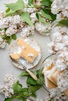 gebeten wafel ijs room in kom en Aan een schotel, lente nog steeds leven met boeket van wit seringen, antiek porselein reeks foto