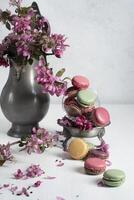 voorjaar nog steeds leven met gekleurde bitterkoekjes en roze appel boom bloemen in een tin foto