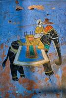 muurschildering van maharadja Aan olifant Aan blauw huis muur in jodhpur foto