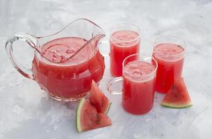 vers rood watermeloen drinken Aan heet zomer dag Aan licht grijs cement achtergrond foto