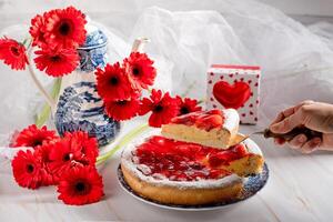 nog steeds leven aardbei taart met pudding en een waterkoker met een boeket van rood gerbera's, een geschenk voor Valentijnsdag dag foto