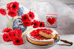 nog steeds leven aardbei taart met pudding en een waterkoker met een boeket van rood gerbera's, een geschenk voor Valentijnsdag dag foto